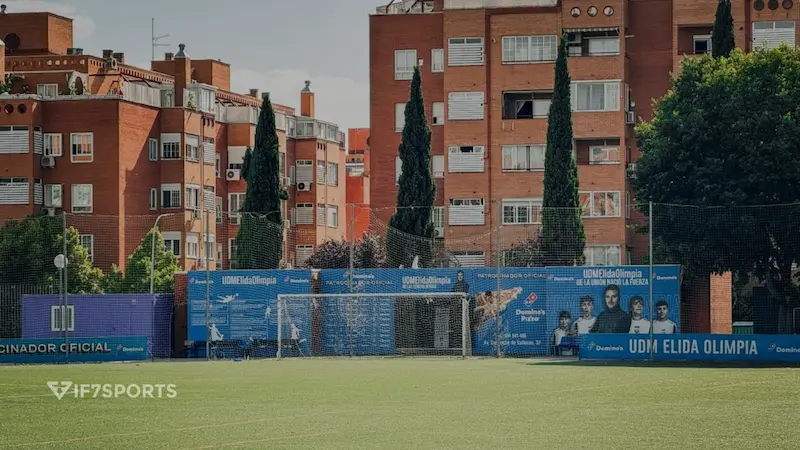 Vue du terrain de football de l'UDM Elida Olimpia à Vallecas, Madrid, avec des filets et des immeubles résidentiels en arrière-plan