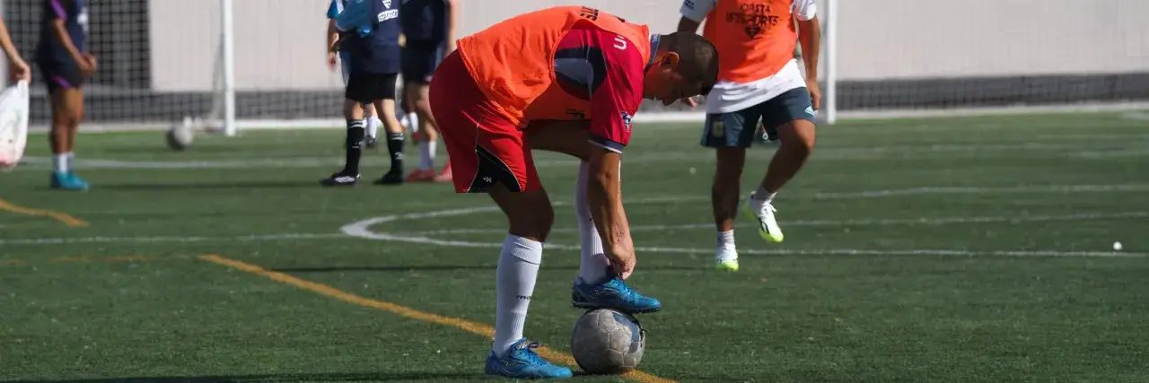 Joueur attachant ses lacets en marchant sur le ballon