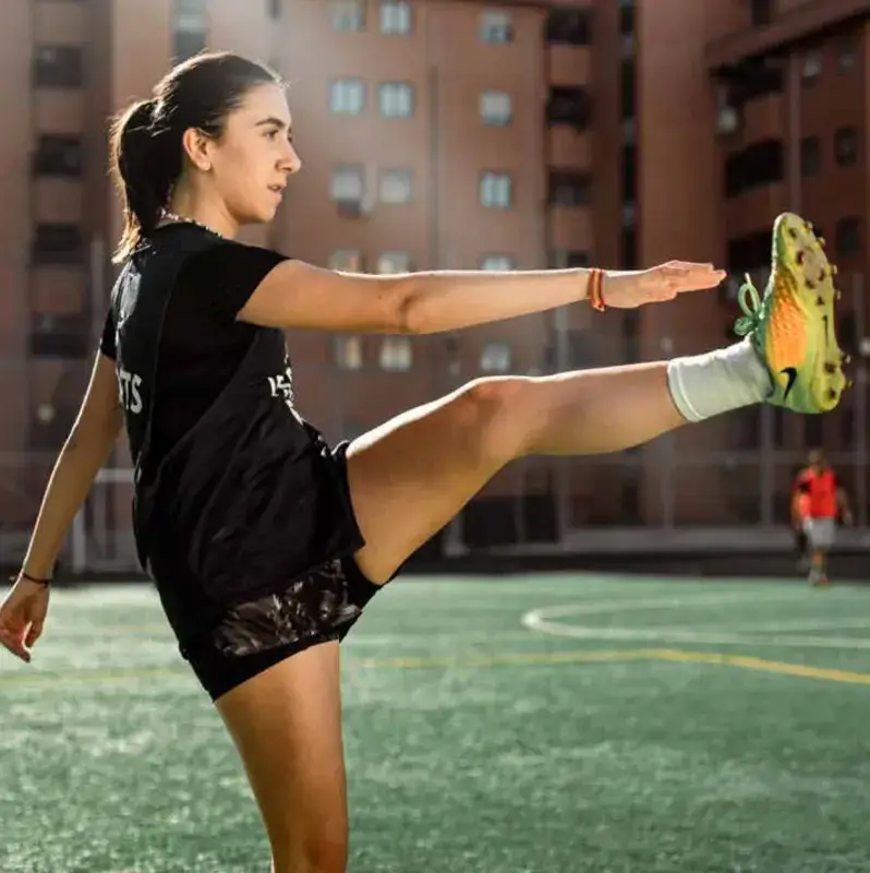 Jugadora de fútbol femenino dominando el balón con el peto negro de IF7SPORTS