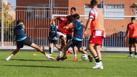 Jugadores disputando un partido de fútbol amateur organizado