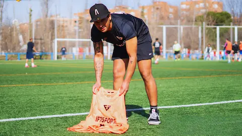 Organizador recogiendo material después de un partido de fútbol amateur