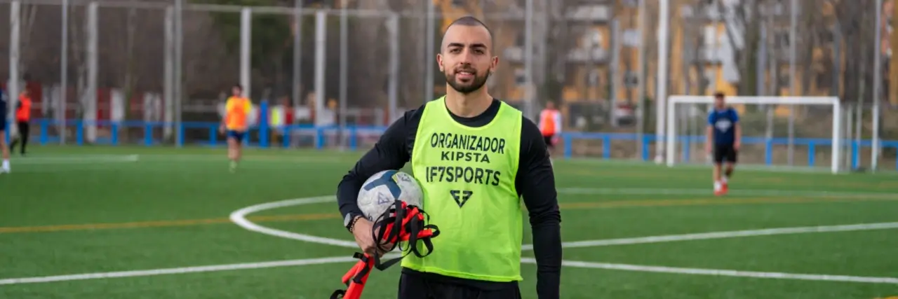 Organizador de IF7SPORTS sonriendo a cámara y sosteniendo equipo deportivo